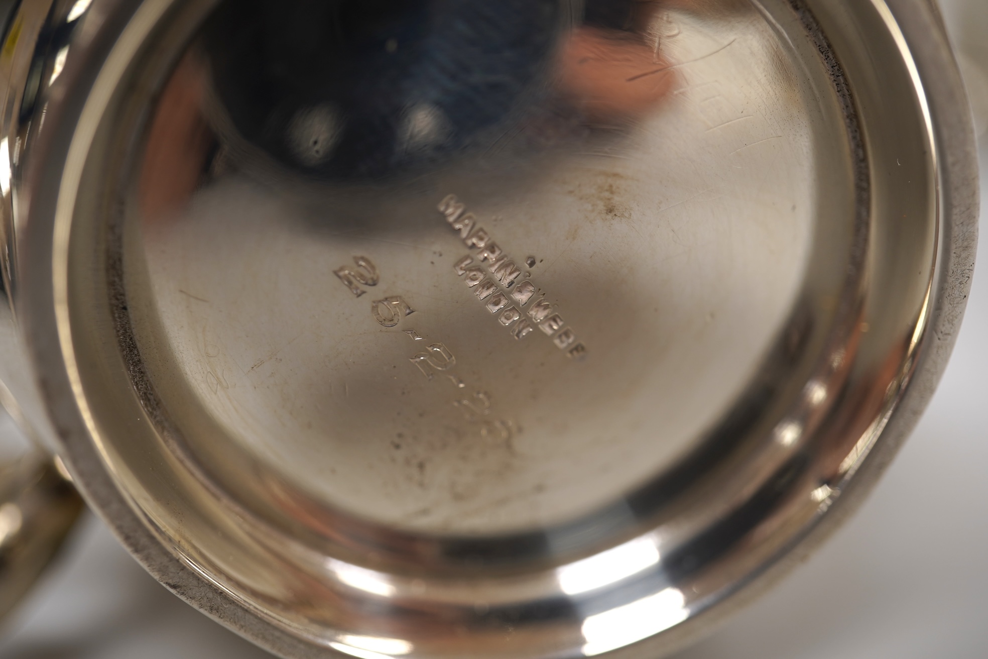 A George V engraved silver tea cup by Mappin & Webb, London, 1924, height 69mm, together with a Gorham sterling beaker and an Edwardian silver christening mug, 11oz.